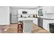 Bright kitchen featuring white cabinets, a central island with seating, and modern appliances at 403 Greenbriar S Rd, Statesville, NC 28625