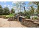 Backyard featuring a built-in grill area, brick patio, privacy fence, and access to the pool at 405 Downing Dr, Kings Mountain, NC 28086