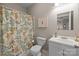 The bathroom features a shower with a patterned curtain, a white toilet and a white sink at 405 Downing Dr, Kings Mountain, NC 28086