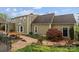 Exterior showcasing brick pathway, landscaped yard, and neutral siding of the home's rear facade at 405 Downing Dr, Kings Mountain, NC 28086