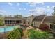 Backyard view featuring a pool, screened porch, brick patio, and well-maintained lawn on a sunny day at 405 Downing Dr, Kings Mountain, NC 28086