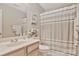 Well-lit bathroom features a sink with wooden cabinets, a decorative shower curtain and a decorative picture at 4517 Sabin St, Rock Hill, SC 29732