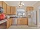 Well-lit kitchen with stainless steel appliances, wooden cabinets, and a view into an adjacent room at 4517 Sabin St, Rock Hill, SC 29732