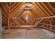 Spacious unfinished attic displaying exposed wood beams and a window for natural light at 4637 Gold Finch Dr, Denver, NC 28037