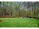 Backyard with manicured lawn and a wood privacy fence bordering a wooded area at 4637 Gold Finch Dr, Denver, NC 28037