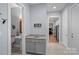 Bright hallway view featuring a hall bath, gray cabinets, and views into the living room at 4637 Gold Finch Dr, Denver, NC 28037