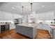 Gourmet kitchen with stainless steel appliances, gray island, and stylish pendant lighting at 4637 Gold Finch Dr, Denver, NC 28037