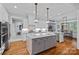 Bright kitchen features a large center island, hardwood floors, and modern light fixtures at 4637 Gold Finch Dr, Denver, NC 28037