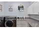 Well-equipped laundry room features modern washer/dryer, granite countertop and cabinet storage, and utility sink at 4637 Gold Finch Dr, Denver, NC 28037