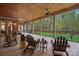 Covered porch featuring wood ceiling, brick accents, rocking and Adirondack chairs, and views of the backyard at 4637 Gold Finch Dr, Denver, NC 28037