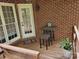 Back porch with brick walls, outdoor seating, and a door leading to the home's interior at 481 Patriot Ne Ct, Concord, NC 28025