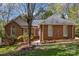 Charming brick home with a well-manicured lawn and mature trees creating a welcoming curb appeal at 481 Patriot Ne Ct, Concord, NC 28025