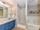 Bathroom featuring a blue vanity, a glass shower and a soaking tub at 5043 Hickory Lake Ln, Matthews, NC 28105