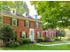Beautiful brick home with dormer windows, a well-manicured lawn, and lush landscaping at 5043 Hickory Lake Ln, Matthews, NC 28105