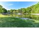 A picturesque pond with a fountain surrounded by lush greenery, creating a tranquil ambiance at 5043 Hickory Lake Ln, Matthews, NC 28105