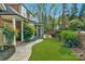Beautiful backyard with lush landscaping, artificial turf, and a brick patio at 5750 Hemby Rd, Matthews, NC 28104