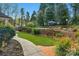 Serene backyard oasis with artificial turf, brick retaining wall, and a glimpse of the inviting swimming pool at 5750 Hemby Rd, Matthews, NC 28104