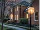 Well-maintained brick home featuring manicured landscaping and an inviting entryway with a decorative lantern at 5750 Hemby Rd, Matthews, NC 28104