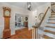 Charming foyer with hardwood floors, staircase, grandfather clock, and view into study at 5750 Hemby Rd, Matthews, NC 28104