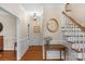 Inviting foyer features hardwood floors, wainscoting, staircase, and decorative mirror at 5750 Hemby Rd, Matthews, NC 28104