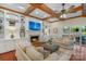 Open living room with coffered ceilings, custom built-ins, fireplace, and access to screened porch at 5750 Hemby Rd, Matthews, NC 28104