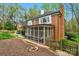 Rear view of the brick home showcasing a lovely screened-in porch, chimney, and manicured landscaping at 5750 Hemby Rd, Matthews, NC 28104