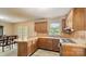Efficient kitchen featuring wood cabinets, laminate countertops, and modern flooring leading to the dining room at 600 Community Ln, Lancaster, SC 29720