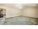 Spacious living room with neutral walls, dated carpeting, and a chandelier at 600 Community Ln, Lancaster, SC 29720