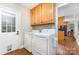 Bright laundry room with wooden cabinets, appliances, and access to outdoor space at 608 Grace St, Shelby, NC 28150