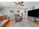 Living room featuring hardwood floors, a ceiling fan, comfortable seating and a large television at 608 Grace St, Shelby, NC 28150