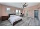 Well-lit bedroom with ceiling fan, natural light, and adjoining bathroom at 610 Blaise Ct, Matthews, NC 28104