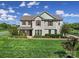 Charming two-story home featuring a well-manicured lawn and beautiful landscaping under a bright, partly cloudy sky at 610 Blaise Ct, Matthews, NC 28104