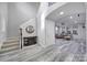 Bright foyer featuring a staircase, wood-look flooring, and a decorative mirror above a wooden console table at 610 Blaise Ct, Matthews, NC 28104