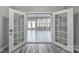 View of large, naturally lit living room with double doors leading to the back of the property at 610 Blaise Ct, Matthews, NC 28104