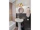 Cozy bathroom with pedestal sink, black wainscoting, decorative tile accents, and vintage-style lighting at 612 Rowan Mill Rd, Salisbury, NC 28147