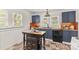 A well-lit kitchen featuring an island, stainless steel appliances, and uniquely tiled backsplash at 612 Rowan Mill Rd, Salisbury, NC 28147