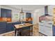 Bright kitchen featuring an island, black appliances, unique backsplash, and a modern vent hood at 612 Rowan Mill Rd, Salisbury, NC 28147