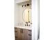 Modern half bath with vanity, dark fixtures, and round mirror at 6718 Rollingridge Dr, Charlotte, NC 28211