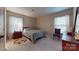 Sunny bedroom features a bed, side tables, two sunny windows and neutral carpet create a welcoming space at 7626 Surreywood Pl, Charlotte, NC 28270
