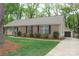 Charming brick home with manicured lawn, brown shutters, and a detached garage in a peaceful, wooded setting at 7626 Surreywood Pl, Charlotte, NC 28270