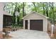 Detached garage with basketball hoop, seating area, and a pedestrian door, perfect for workshop at 7626 Surreywood Pl, Charlotte, NC 28270