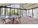 An expansive screened porch is well furnished for outdoor living and provides great views of the home's green landscape at 7626 Surreywood Pl, Charlotte, NC 28270