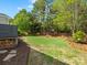 Well-maintained backyard with a green lawn, privacy fence, and wood storage near the house at 7822 Noland Woods Dr, Charlotte, NC 28277