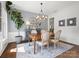 Bright dining area featuring wainscoting, modern chandelier, and a stylish accent wall at 7822 Noland Woods Dr, Charlotte, NC 28277