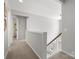 Upstairs hallway featuring carpet, white walls, wood railing, and overhead lighting at 7822 Noland Woods Dr, Charlotte, NC 28277