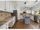 Bright kitchen featuring granite countertops, stainless steel appliances, a kitchen island, and hardwood floors at 7822 Noland Woods Dr, Charlotte, NC 28277