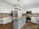Bright kitchen featuring granite countertops, stainless steel appliances, a kitchen island, and hardwood floors at 7822 Noland Woods Dr, Charlotte, NC 28277