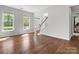 Spacious room showcasing hardwood floors, a grand staircase, and abundant natural light at 7822 Noland Woods Dr, Charlotte, NC 28277