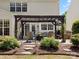 Charming outdoor patio with a pergola, comfortable seating, mature landscaping, and stone pathway at 7822 Noland Woods Dr, Charlotte, NC 28277