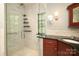 Modern bathroom features a glass shower, dark countertops and stylish fixtures with natural light from windows at 801 Berkeley Ave, Charlotte, NC 28203